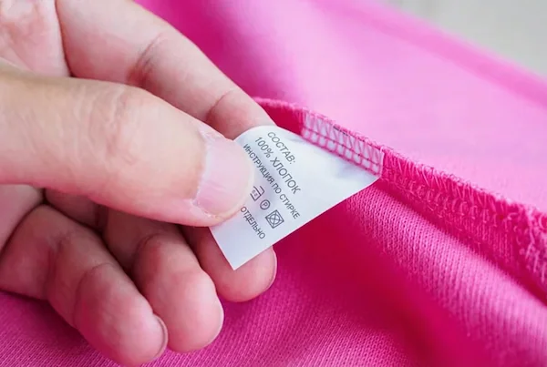 primer plano de prendas importadas con etiquetas en otro idioma que incumplen con las normativas de etiquetado textil