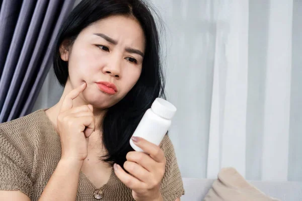 mujer leyendo la etiqueta de un frasco de medicamentos