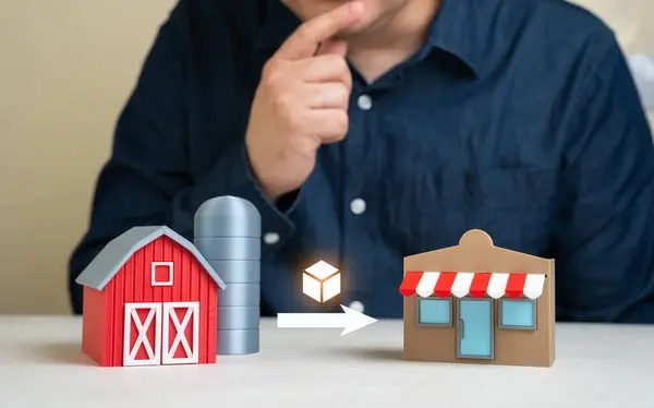 hombre mirando una figura de granja a escala y una tienda a escala, lo que representa la trazabilidad alimentaria: De la granja a la tienda