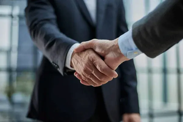 empresarios estrechando las manos cerrando una alianza estratégica