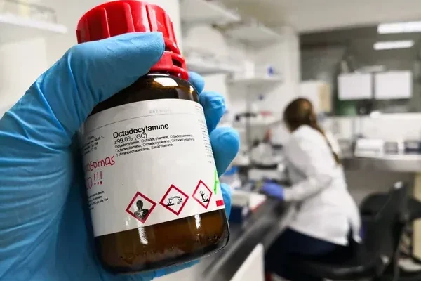 frasco de químico corrosivo correctamente etiquetado según las normas GHS