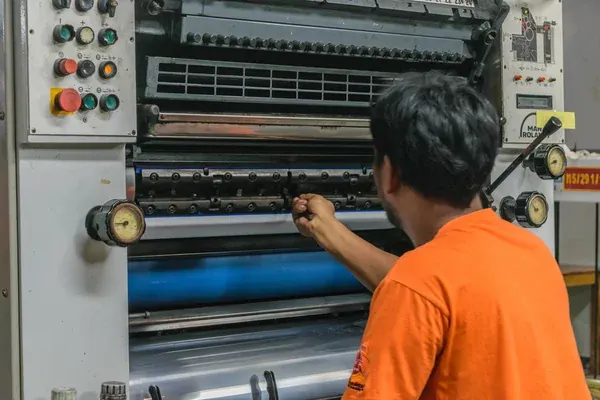 trabajador calibrando impresora flexográfica 